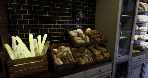 Freshly baked bread displayed in rustic wooden crates inside a bakery Stock Footage 318686965