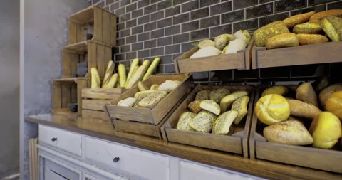 Freshly baked bread displayed in rustic wooden crates at a cozy bakery Stock Footage 318793293
