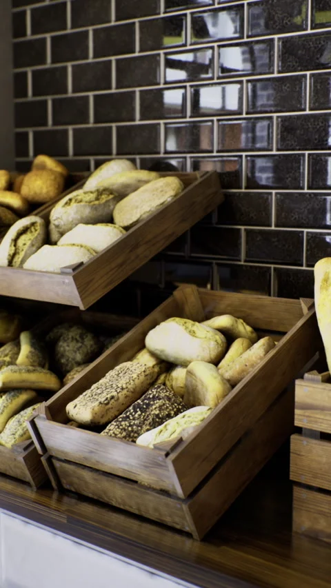 Freshly baked bread displayed in rustic wooden crates in bakery shop Stock Footage 318837201