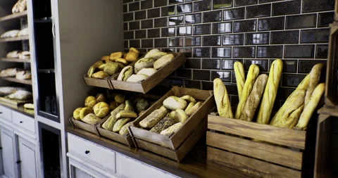 Freshly baked bread displayed in rustic wooden crates in bakery shop Stock Footage 319748873