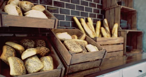 Freshly baked bread displayed in rustic wooden crates at a cozy bakery Stock Footage 320269453