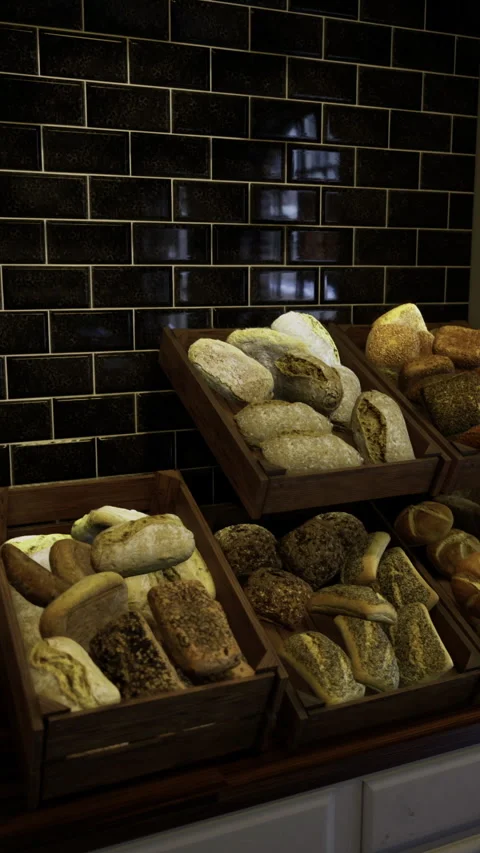 Freshly baked bread displayed in rustic wooden crates inside a bakery Stock Footage 325075282