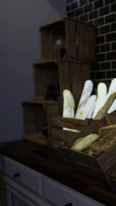 Freshly baked bread displayed in rustic wooden crates at a cozy bakery Stock Footage 331692157