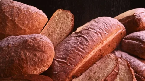 Freshly baked bread laid out after baking, sprinkled with flour and spices Stock Footage 148507372