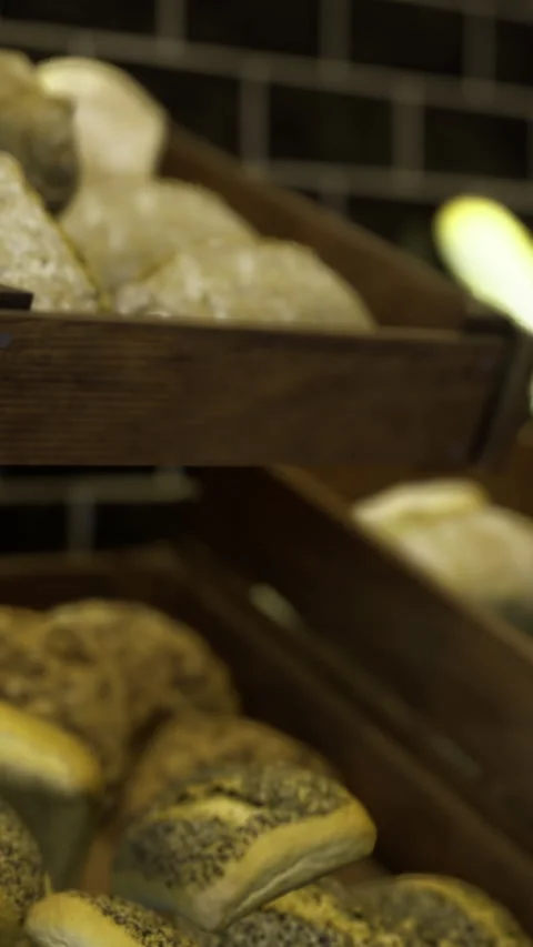 Freshly baked bread loaves resting on rustic wooden shelves at a bakery Stock Footage 342460965