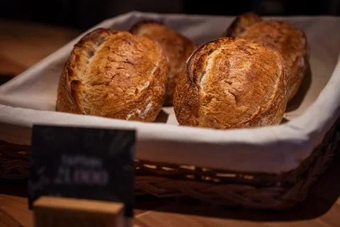 Freshly baked bread loaves in rustic basket at cozy bakery Stock Photos