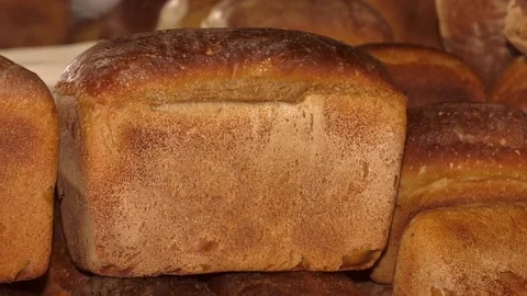 Freshly baked bread loaves at window of store front. Video stock 122279529