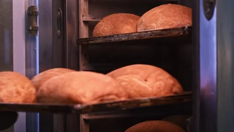 Freshly baked bread on racks is taken out of the oven Stock Footage 148507331