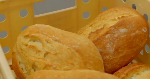 Freshly baked bread rolls arranged inside perforated bakery crate with warm Stock Footage 344588889