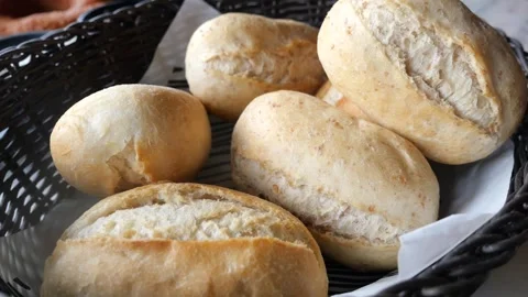 Freshly baked bread rolls in dark wicker basket on white table with soft na.. Stock Footage 332578172