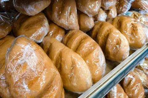 Freshly baked bread rolls packaged for sale in a local market during the morning Stock Photos
