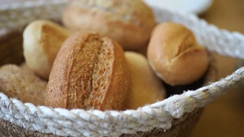 Freshly baked bread rolls in a woven basket ready for a delicious breakfast.. Stock Footage 332044220