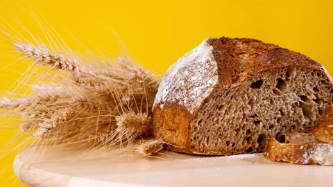 Freshly Baked Bread in Rustic Setting on Yellow Background Stock Footage 202738723
