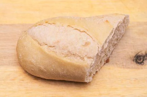 Freshly baked bread slice on a wooden cutting board, ready to eat Stock Photos