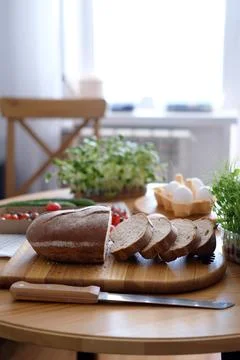 Freshly baked bread on the table cut into slices for sandwiches for breakfast or Stock Photos