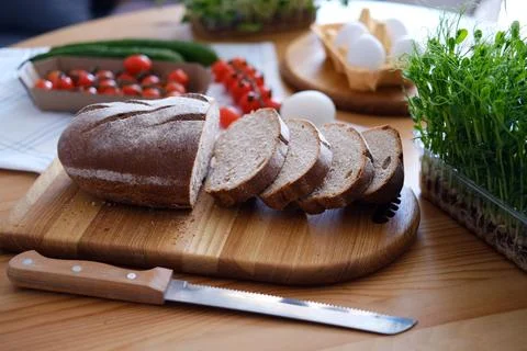 Freshly baked bread on the table cut into slices for sandwiches for breakfast or Stock Photos