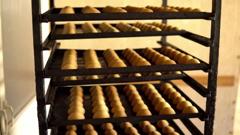 Freshly baked buns arranged on a multi-level trolley Stock Footage 240579544