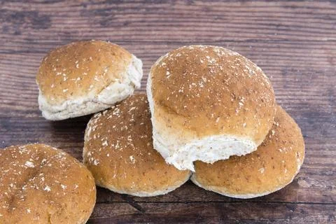 Freshly baked buns rest on a rustic wooden surface 스톡 사진