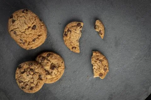 Freshly baked Chocolate chip cookies on a dark stone with place for text. Cop Stock Photos