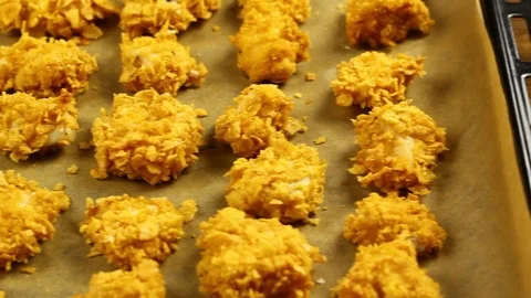 Freshly baked corn flake crumbs chicken nuggets on baking sheet Stock Footage 77222115