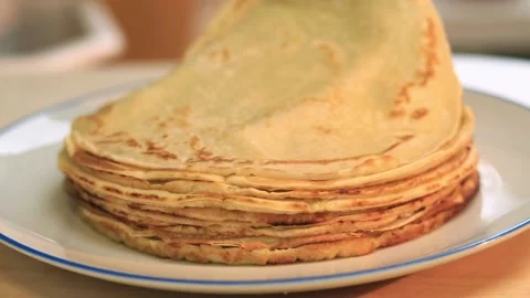 Freshly baked crepes, adding a new crepе to the stack. Cooking pancakes Stock Footage 229640435