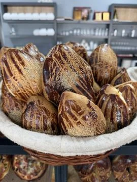 Freshly baked crispy bread rolls in a basket displayed on a bakery counter .. Stock Photos