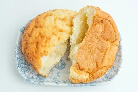 Freshly baked cut bread bun with sweet filling on a white plate isolated on.. Stock Photos