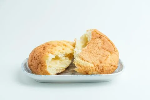 Freshly baked cut bread bun with sweet filling on a white plate isolated on.. Stock Photos