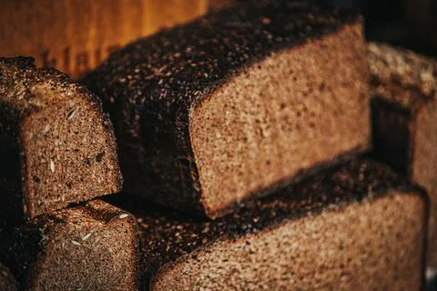 Freshly baked dark rye bread loaves stacked on wooden surface with a rustic.. Stock Photos