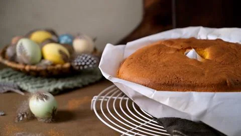 Freshly baked Easter cake cooling on a wire rack with decorative eggs Stock Photos