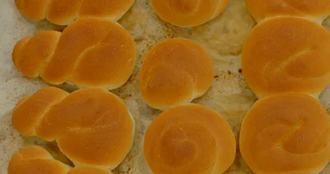 Freshly baked golden bread rolls on parchment-lined tray top-down flatlay Stock Footage 344582824