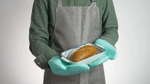 A freshly baked loaf of bread in a baking pan in the hands of a man Stock Footage 311069337