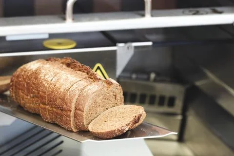 Freshly baked loaf of rustic bread with crusty exterior. Slices cut, revealin Fotos de archivo