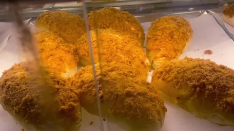 Freshly baked meat floss bread displayed in a bakery showcase 動画素材 341897859