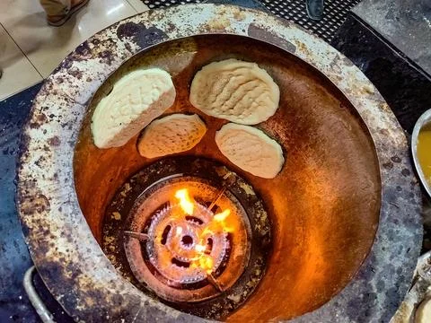 Freshly baked Middle Eastern bread cooking inside a traditional clay oven. Foto stock
