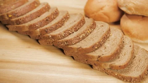 Freshly baked multi-grain bread slices beautifully placed on a wooden table Stock Footage 197738428