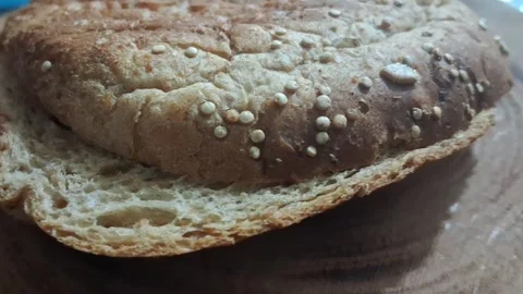 Freshly baked multigrain bread bun moving in slow motion video clip Stock Footage 339249033