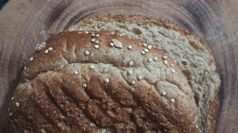 Freshly baked multigrain bread slice resting on a wooden board Stock Photos