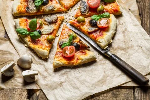 Freshly baked pizza split and given on baking paper Foto stock