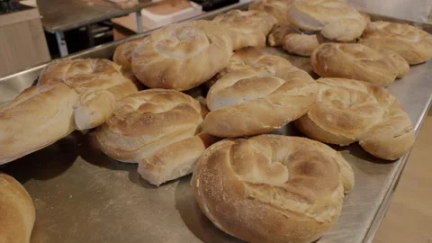 Freshly baked round bread rolls displayed on a metal tray in a bakery Stock Footage 340172485