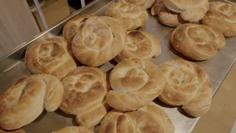 Freshly baked round bread rolls arranged on a metal tray, showcasing their Stock Footage 340172668
