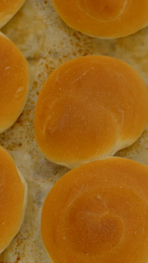 Freshly baked round bread rolls on tray with warm bakery lighting and tight Stock Footage 344571866