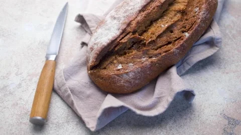 Freshly baked rustic bread loaf with knife Stock Footage 336098962