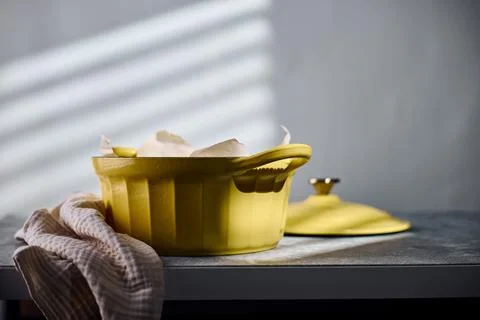 Freshly baked rustic bread in yellow cast iron Dutch oven Description: Stock Photos