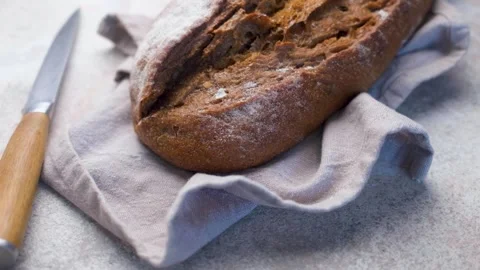 Freshly baked rye bread loaf resting on linen napkin Stock Footage 336257992