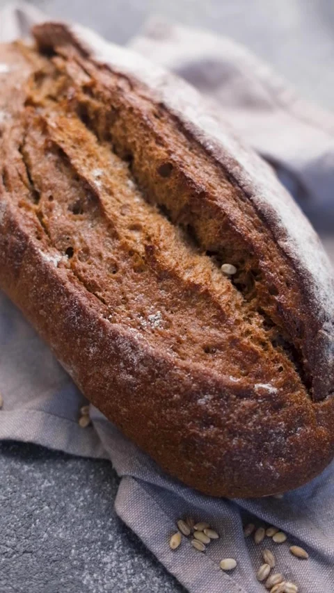 Freshly baked rye bread loaf rotating Stock Footage 336550054
