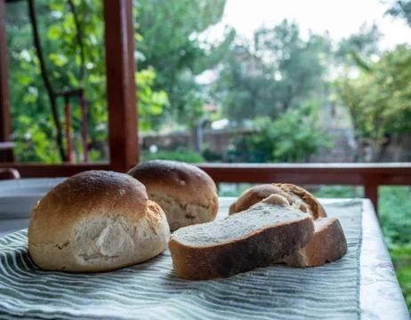 Freshly baked sliced bread on the table with nature scene. Stock Photos