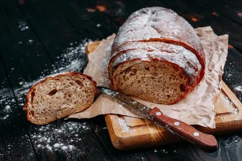 Freshly baked sliced rye bread on wooden cutting board Stock Photos