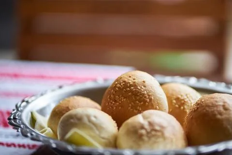 Freshly baked small bread rolls topped with sesame seeds served in a metal bo Stock Photos