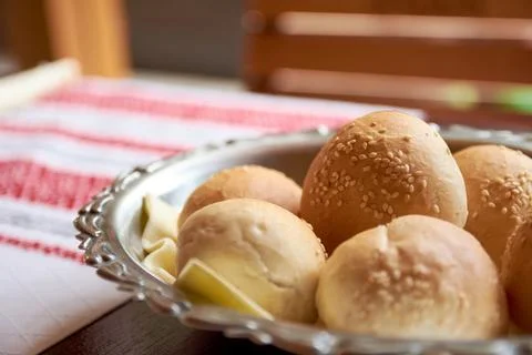 Freshly baked small round bread rolls with sesame seeds arranged in a decor.. Stock Photos